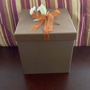 Pretty storage/gift box. Cardboard. Bronzish color with orange ribbon and flower
